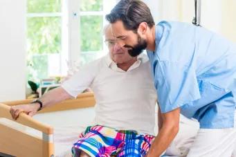 Infirmier aidant une personne à sortir de son lit