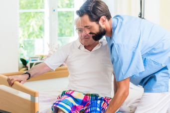 Infirmier aidant une personne à sortir de son lit