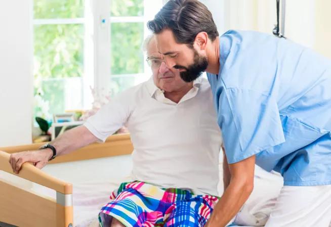 Infirmier aidant une personne à sortir de son lit